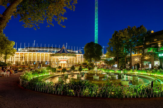 Copenhagen, Denmark. Circa August 2022. Magical Tivoli Gardens at night with rides and buildings with lights. Popular amusement park very important tourist attraction