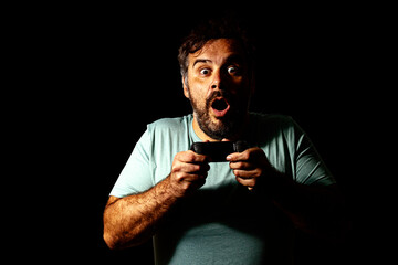 Man holding video game controller and expressing surprise while playing video game.