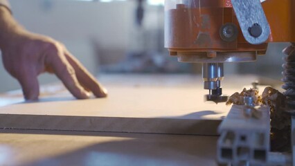 Electric carpentry tools. Carpentry workshop.
Drilling wood with circular knife in carpentry workshop.
