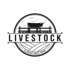 Vintage cattle farm logo with silhouette cows and ranch fence. Vector illustration.