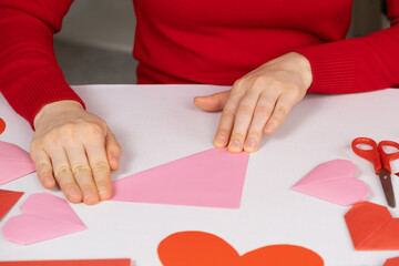 Obraz premium Making origami hearts for Valentine's Day. Crafts made of paper with your own hands.