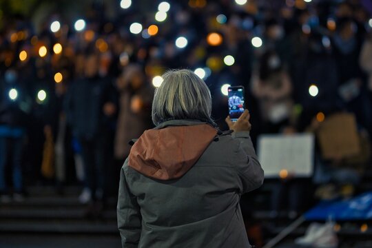 Woman Live Streaming A Group Of People Lightening Candles In The Tiananmen Square Massacre Vigil