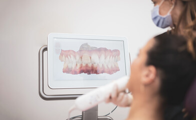 Dentist woman scanning patient's teeth with 3d dental scanner in modern clinic, 3d jaw intraoral...