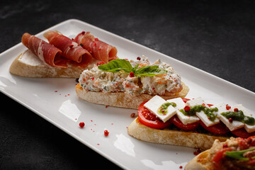 Various Bruschettas with ham, seafood, vegetables and cheese