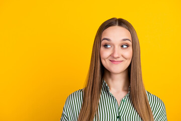 Indoor close up cheerful female in shirt, looking aside with charming smile posing over yellow color background