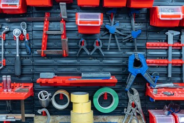 Professional work tools hanging on steel wall as background