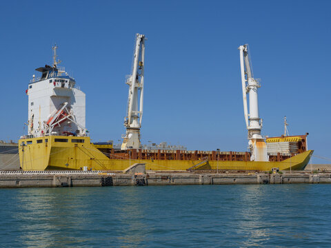 Cargo Ship Under Maintenance at a Shipyard with Two High Cranes