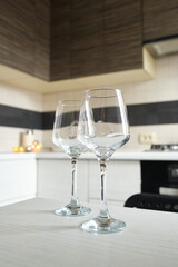 Two glasses of white wine on the kitchen table. Celebrate and enjoy the moment. Tasting of alcoholic beverages. Glass of wine close-up