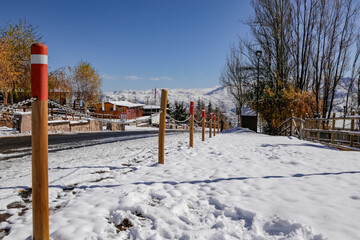 winter landscape covered with snow and mountains in the background with wooden fence full of snow after a blizzard