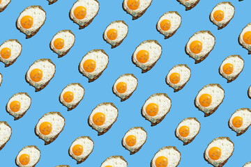 hard light pattern of a fried egg with unbroken egg yolk on a seamless blue background