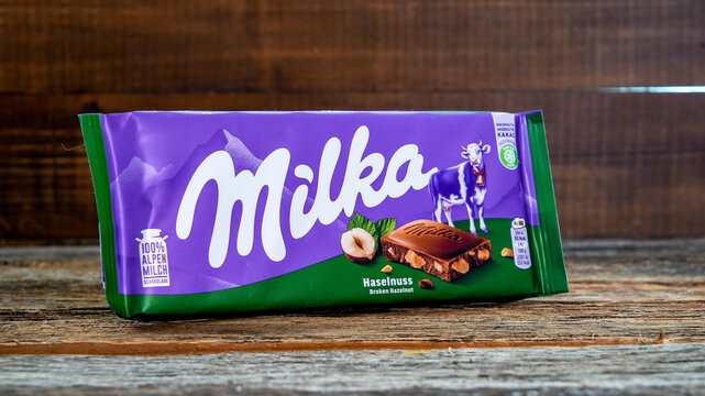 NORWALK, CT, USA - NOVEMBER 18, 2022: Milka chocolate with broken hazelnut on wooden table