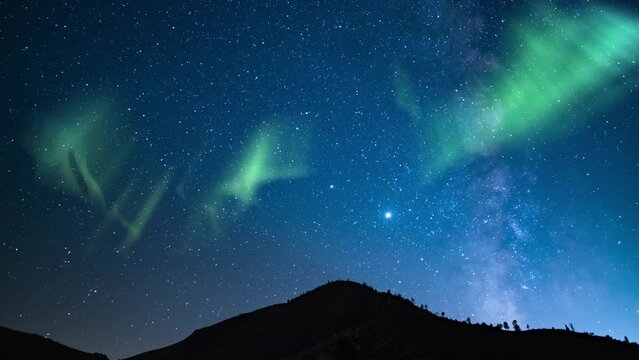 Aurora Green and Milky Way Time Lapse Over Forest Mountain