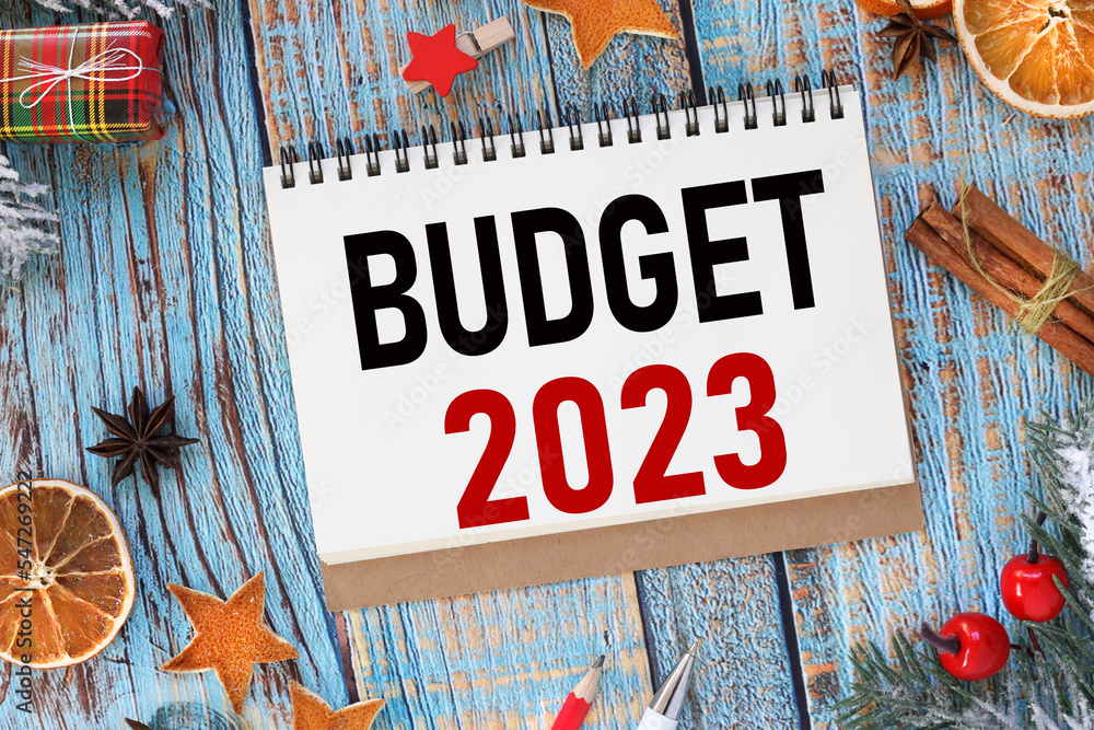 Poster 2023 budget. blue background.new year theme. text on the page of an open notebook