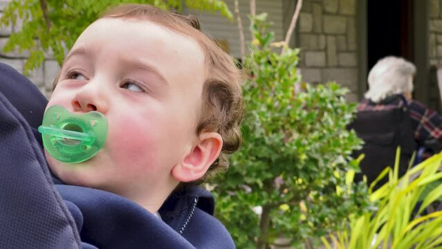 Young kid on the stroller with the pacifier