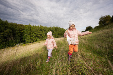 Fototapeta premium Sisters having fun and run outdoor near forest.