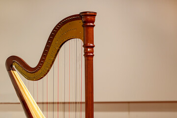 Partial view of a concert harp against a light background