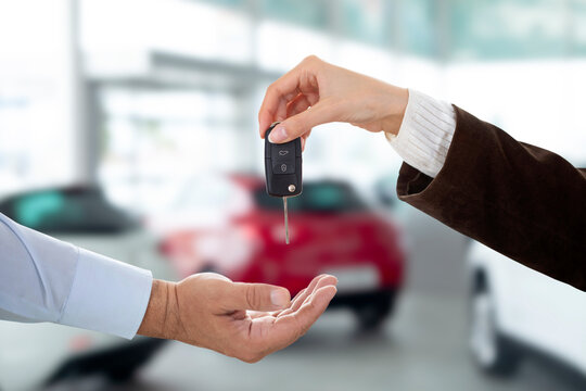 young sales woman giving car key