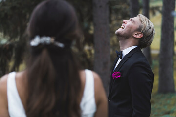 Focus on blond bearded laughing Scandinavian groom in elegant black tuxedo with butterfly tie and...