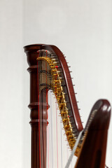 Partial view of a concert harp against a light background