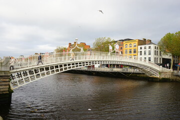 Fototapeta na wymiar Ha'penny Bridge over River Liffey and City View of Dublin City in Ireland