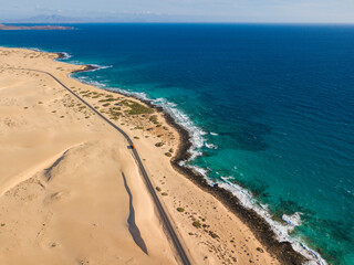 Rocky coastline and highway with golden sand and blue water