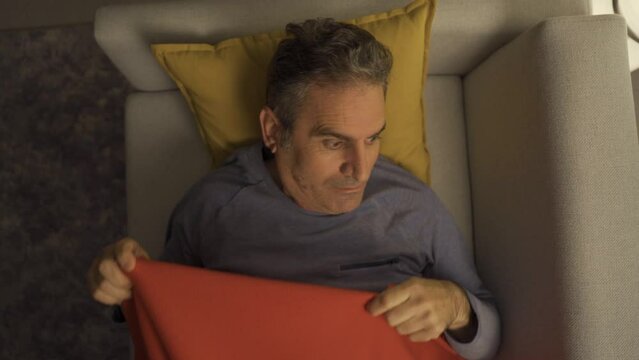 The man with sleep disorders cannot sleep.
Mature man wakes up from sleep and tries to sleep again.
