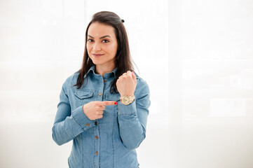 A mulher empreendedora em uma sessão de fotos corporativa em uma pose de pé apontando com a mão...