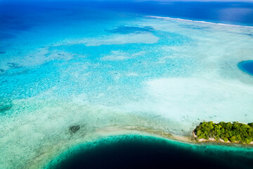 Aerial shot of shallow coral reef and atoll in Pacific Ocean 