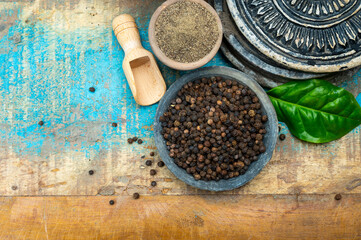 Indian spices collection, dried black peppercorns and another spices in clay bowls