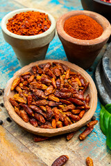 Colorful ground spicy chili peppers , pimento and curcuma is clay pots close up