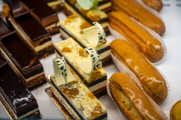 Assortment of french fresh baked sweet pastry with fresh fruits and berries in confectionery shop