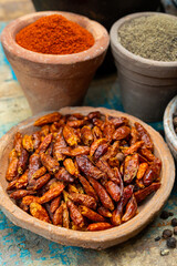 Colorful ground spicy chili peppers , pimento and curcuma is clay pots close up