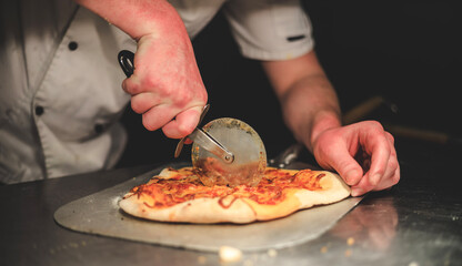 Chef cutting a pizza