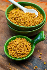 Indian spices collection, dried aromatic fenugreek seeds and another spices in clay green bowl
