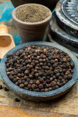 Indian spices collection, dried black peppercorns and another spices in clay bowls