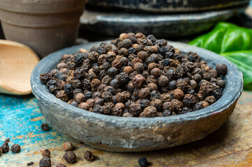 Indian spices collection, dried black peppercorns and another spices in clay bowls