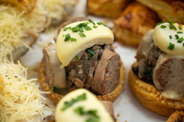 French mini quiche pie with goat cheese and traditional French sausage Andouillette from Troyes in bakery