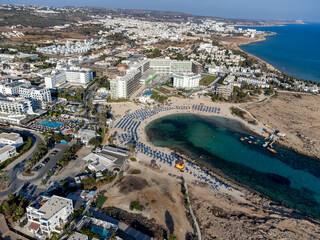 Fototapeta premium Aerial panoramic view on holidays villas and blue crystal clear water on Mediterranean sea near Nissi beach, Ayia Napa, Cyprus