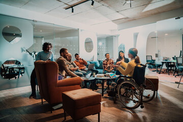 Businesswoman in wheelchair having business meeting with team at modern office. A group of young freelancers agree on new online business projects - Powered by Adobe