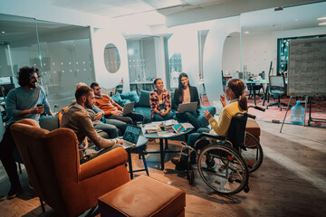 Businesswoman in wheelchair having business meeting with team at modern office. A group of young freelancers agree on new online business projects