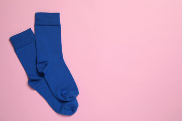 Pair of new blue socks on pink background, flat lay. Space for text