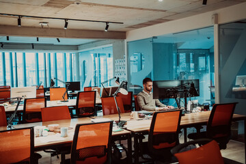 Modern Office: Portrait of Stylish Businessman Works on Computer, Does Data Analysis and Creative Designer, Looks at Camera and Smiles. Digital Entrepreneur Works on e-Commerce Startup Project