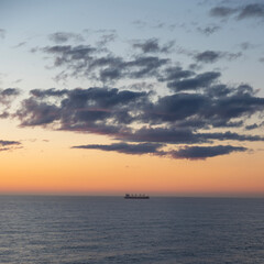 Naklejka na ściany i meble A lonely ship at sea during sunset 
