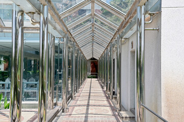 The Tiled corridor under a glass roof of a modern building with abstract design in Thailand.