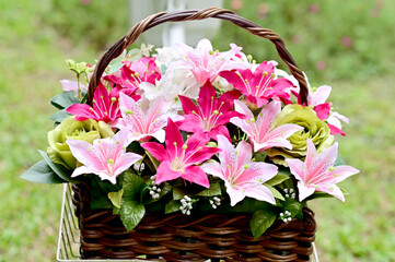 Many colors of fake flowers in the basket on a white bicycle in the park with natural background at Thailand.