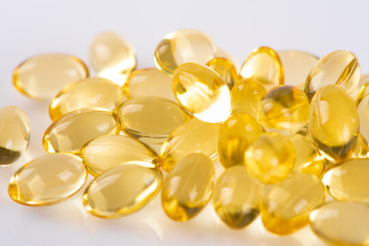 Vitamin E. Supplementary food. Omega 3. Gold fish oil gel Capsules on white background.