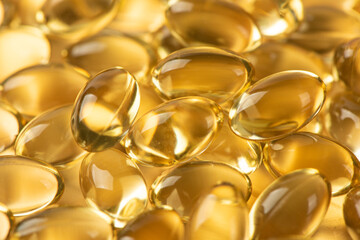 Vitamin E Supplementary food. Omega 3. Gold fish oil gel Capsules background.