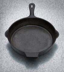 Cast iron frying pan or skillet on a metal bench top