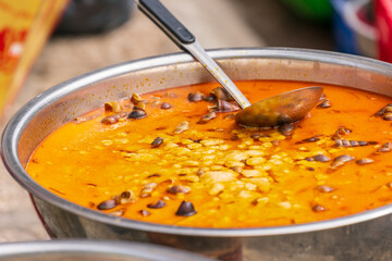 Close up of a colourful bowl of food with a ladle
