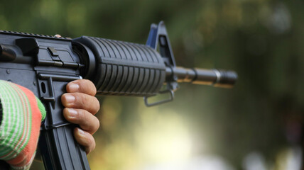 Air soft gun holding by hand aiming in a shooting range, soft and selective focus on the gun       ...